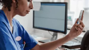 femme qui regarde son téléphone - visio consultation